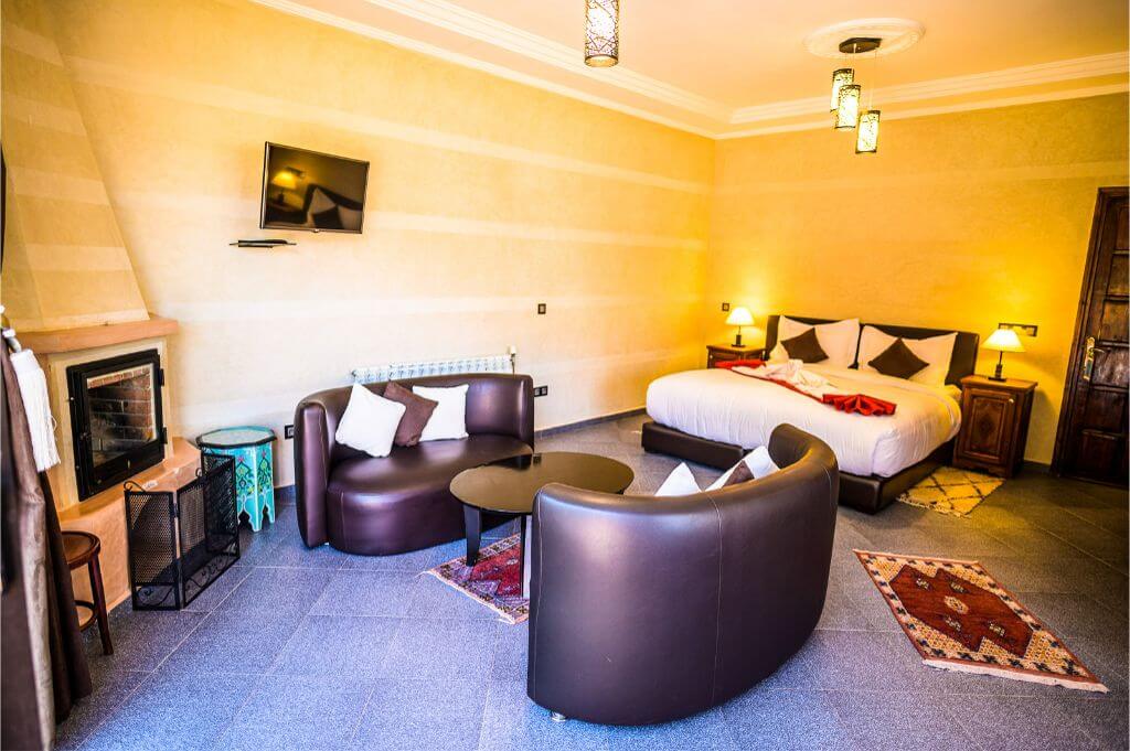 Chambre double confort de l'Hôtel Aurocher avec lit double, cheminée, télévision et coin salon.